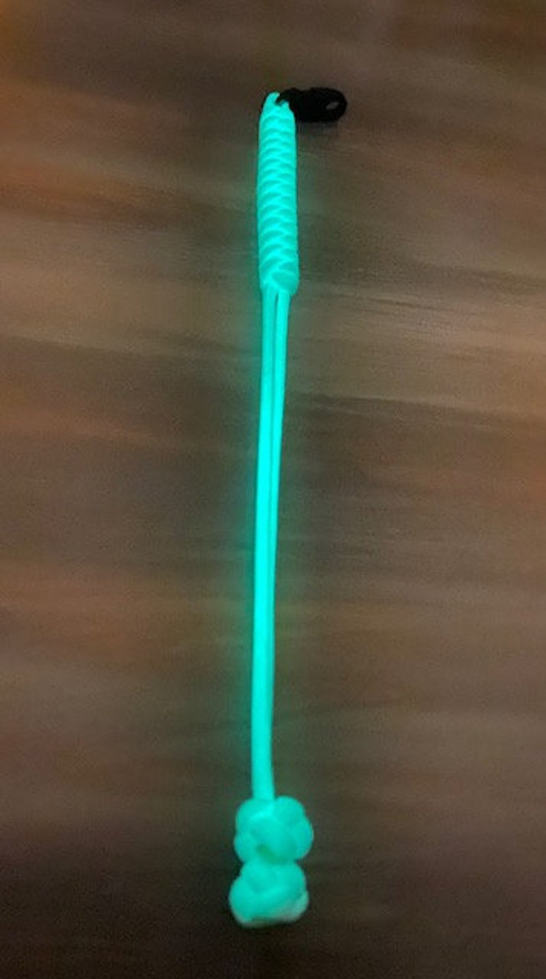 May include: A bright green glow-in-the-dark paracord lanyard with a black clip.