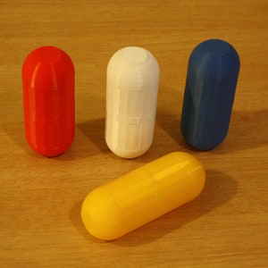 Multicolored Small Storage Capsules - Red, White, Blue, and Yellow Compact Organizer Capsule lids are screwed shut. This image highlights the capsule's design and functionality, featuring multicolored capsules in red, white, blue, and yellow.