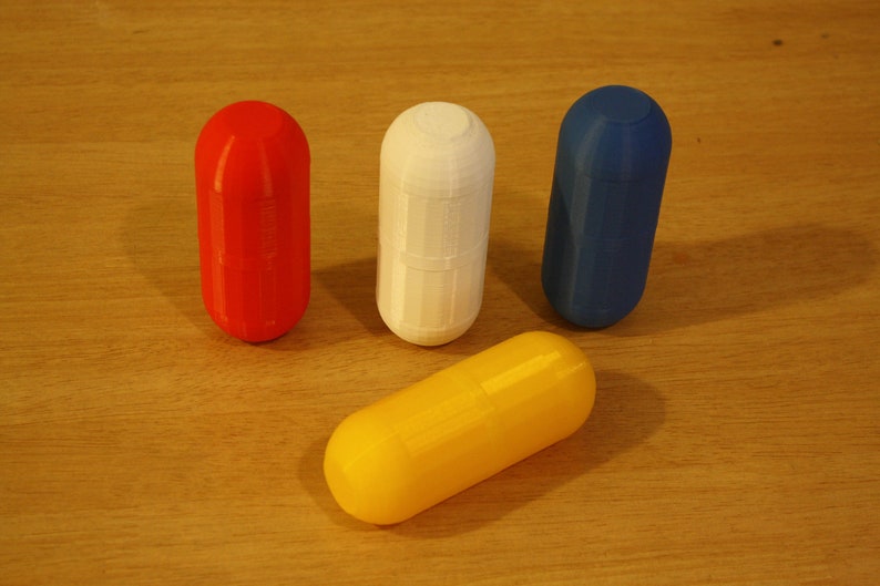 Multicolored Small Storage Capsules - Red, White, Blue, and Yellow Compact Organizer Capsule lids are screwed shut. This image highlights the capsule's design and functionality, featuring multicolored capsules in red, white, blue, and yellow.