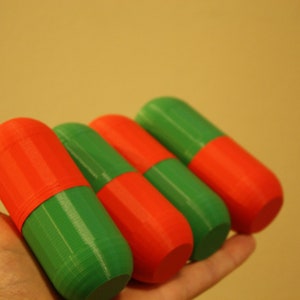 Christmas-Themed Small Storage Capsules - Red and Green Organization and Cosplay Accessories A top-down view of the four small storage capsules in red and green, arranged on a neutral background with a Christmas theme held in one hand.