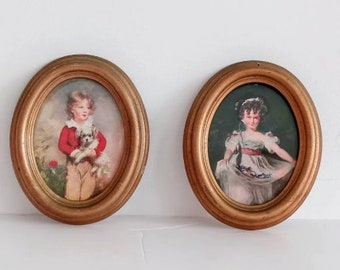 May include: Two oval framed portraits of children. The portrait on the left shows a boy in a red sweater holding a small white dog. The portrait on the right shows a girl in a white dress with a green background.