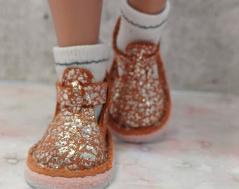 May include: A pair of brown leather ankle boots with silver glitter accents. The boots have a white sole and a pink trim around the top of the sole.