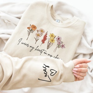 I Wear My Heart On My Sleeve Sweatshirt, Personalize Mom Gift Sweatshirt, Birth Month Flower Gift for Grandma, Gigi Gift, Granny Gift