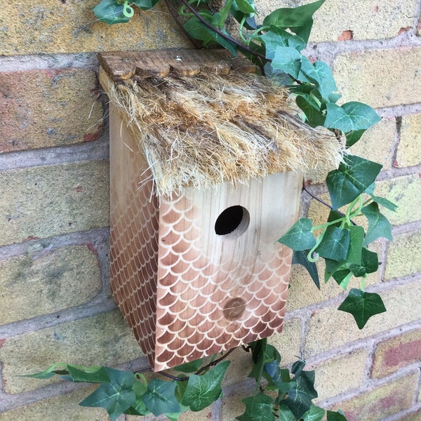 Thatch cottage style bird house.  Wooden and rustic with a tiki style roof.  Nesting box for small garden birds.  A great Christmas gift.