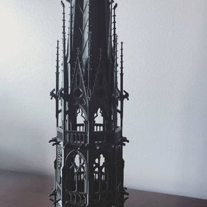 Könnte beinhalten: Ein detailliertes, schwarz 3D-gedrucktes Modell eines gotischen Turms mit filigranen Bögen und Türmen.