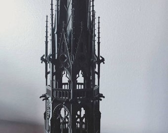Puede incluir: Un modelo de torre gótica en 3D, negro y detallado, impreso con arcos y torres intrincados.