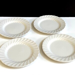 May include: Set of four white ceramic salad plates with a wavy, rippled design.