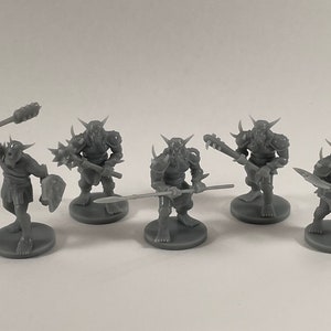 May include: Six gray plastic miniature figures of orcs, each with a different weapon and pose. The figures are standing on round bases.