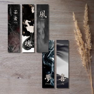 Puede incluir: Cinco marcapáginas en blanco y negro con caracteres japoneses y traducciones al inglés. Los marcapáginas presentan diferentes diseños, incluyendo mármol, tinta, nubes y arena.