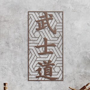 May include: A rectangular, brown metal wall art piece with Japanese characters. The characters are in a vertical arrangement, and the background features a geometric pattern. The art is mounted on a textured, light gray wall.