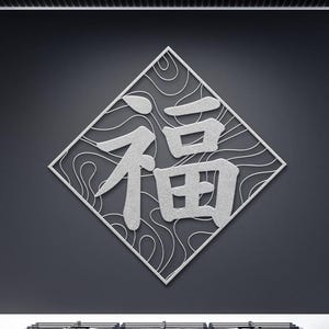 May include: A silver metal wall art piece featuring the Chinese character "Fu" (福), meaning "blessing" or "good fortune." The character is set within a diamond-shaped frame with a decorative, swirling pattern on a dark gray background.
