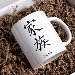 May include: White ceramic mug with black Chinese characters that translate to "Family".
