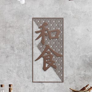 May include: A rectangular wall art piece with Japanese characters in a brown hue. The background features a geometric pattern in shades of gray and white, framed by a brown border. The artwork is mounted on a textured gray wall.