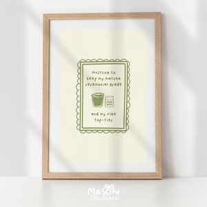 May include: A framed print with a green border and text that reads "Hustling to keep my matcha ceremonial grade and my vibe top-tier". The print features a green illustration of a cup of matcha and a bag of matcha powder.