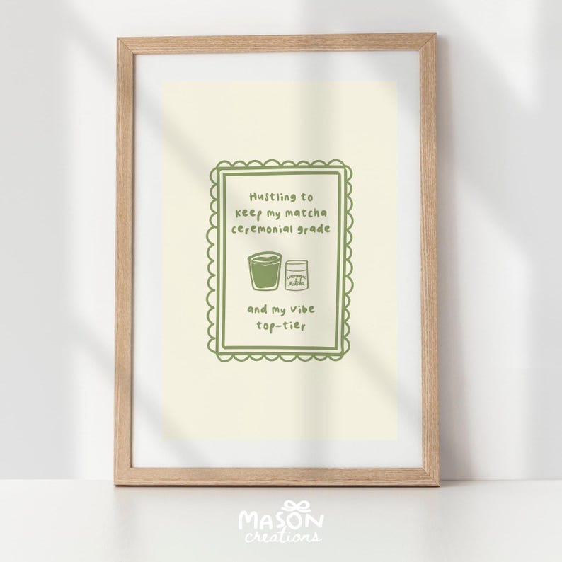 May include: A framed print with a green border and text that reads "Hustling to keep my matcha ceremonial grade and my vibe top-tier". The print features a green illustration of a cup of matcha and a bag of matcha powder.