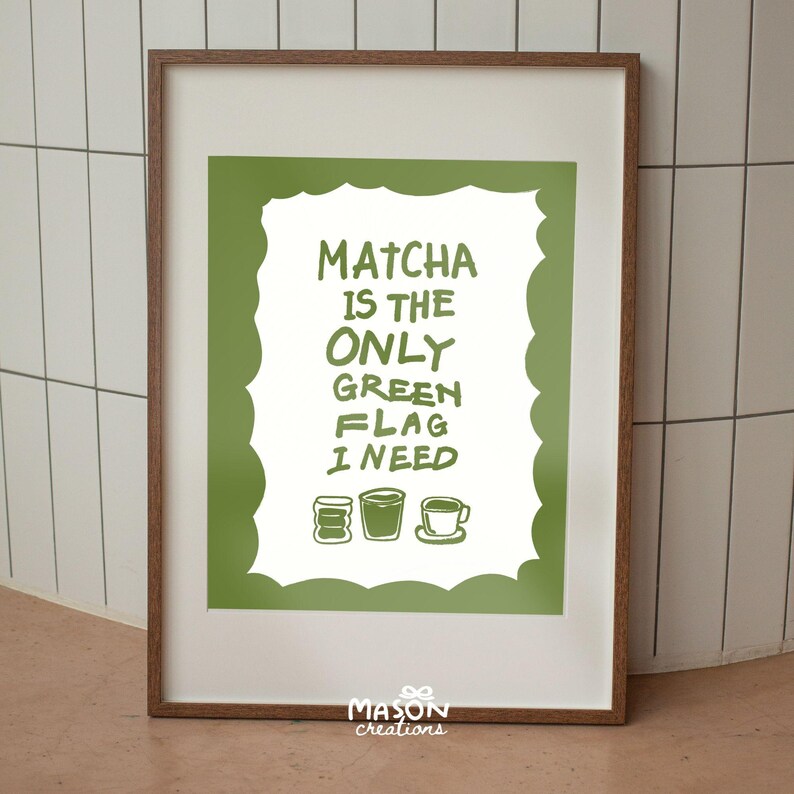 May include: A framed print with a green background and white text that reads "Matcha is the only green flag I need". The text is surrounded by a white cloud shape. There are three green, white, and brown illustrations of matcha tea cups at the bottom of the print.