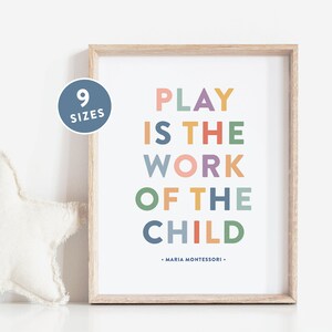 May include: A framed print with the text "PLAY IS THE WORK OF THE CHILD" in colorful letters. The quote is attributed to Maria Montessori.