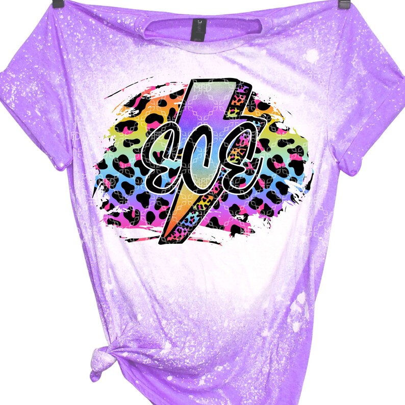 May include: A purple t-shirt with a bleached effect and a rainbow lightning bolt graphic with the word "80s" inside. The graphic is on a leopard print background.