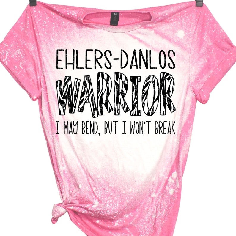 K&ouml;nnte beinhalten: Rosa gebleichtes T-Shirt mit einem schwarz-wei&szlig;en Zebra-Muster, auf dem "Ehlers-Danlos Warrior I may bend, but I won't break" steht.