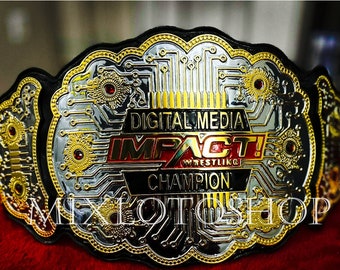 Puede incluir: Un cinturón de campeonato dorado y plateado con fondo negro. El cinturón presenta un diseño de placa de circuito y las palabras "Digital Media Impact! Wrestling Champion".