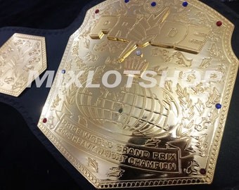 May include: A gold championship belt with the word "PRIDE" in large letters on the front. The belt also features a globe, laurel wreaths, and the text "PRIDE WORLD GRAND PRIX 2004 HEAVY WEIGHT CHAMPION".
