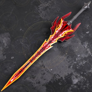May include: A detailed, fantasy-style sword with a red and yellow blade and guard. The blade has a central red design with yellow and white accents. The guard is red with a stylized design. The handle is gray, and the overall design is intricate.