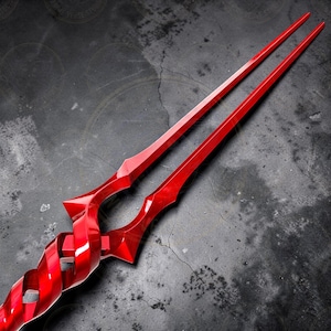 May include: A vibrant red spear with a twisted handle and two long, pointed blades. The weapon has a glossy finish and a detailed, geometric design. The spear is a prop or collectible item.