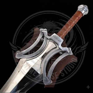 May include: A silver and brown sword with a leather-wrapped handle and a polished blade. The sword features a decorative guard with an engraved design and a silver pommel. The blade is angled towards the viewer.