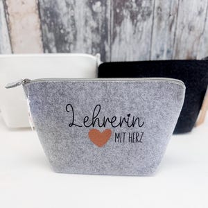 May include: A gray felt zippered pouch with the text "Lehrerin mit Herz" and a small orange heart.