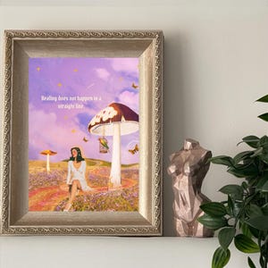 May include: A framed art print with a surreal landscape featuring a woman in a white dress, mushrooms, and butterflies. The text "Healing does not happen in a straight line" is visible. A bronze-coloured bust sculpture is on the right.