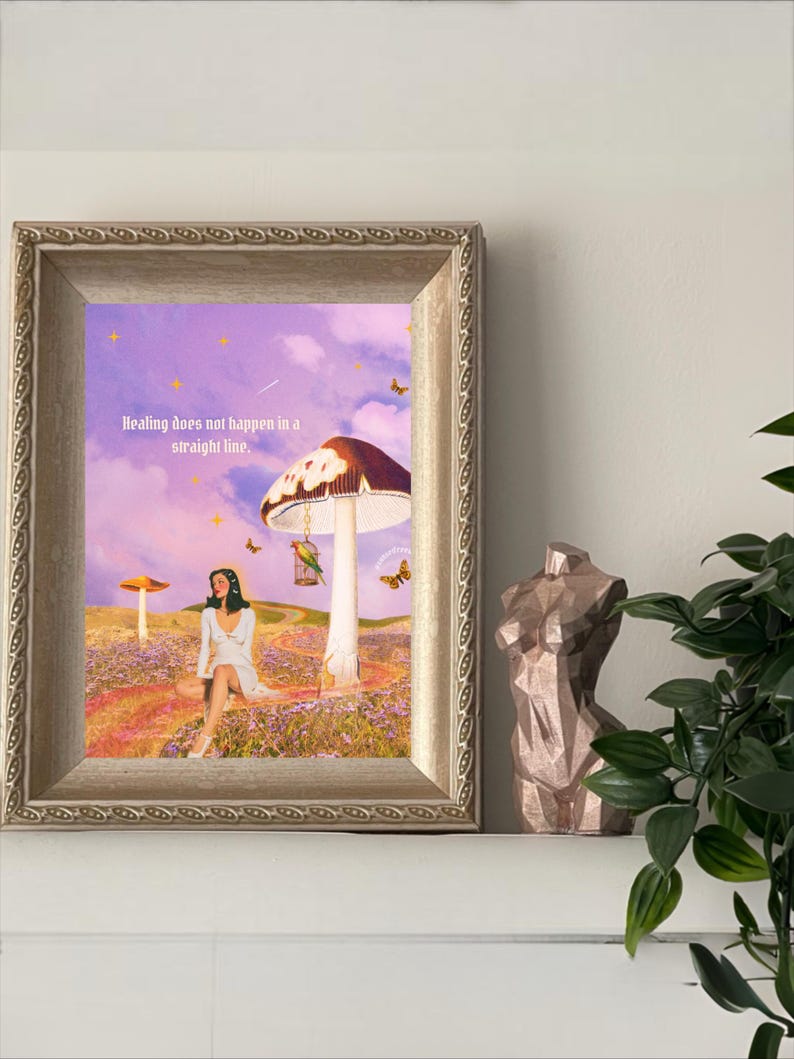 May include: A framed art print with a surreal landscape featuring a woman in a white dress, mushrooms, and butterflies. The text "Healing does not happen in a straight line" is visible. A bronze-coloured bust sculpture is on the right.