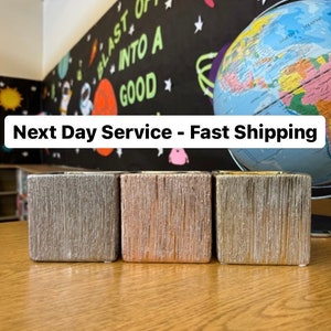 May include: Three square wooden candle holders in silver, rose gold, and gold finishes. The candle holders are arranged in a row on a wooden surface. The text "Next Day Service - Fast Shipping" is visible in the background.