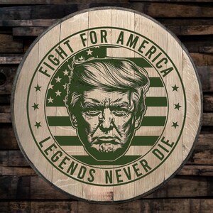 May include: A wooden round sign with a green, white, and red American flag design. The sign features a portrait of a man with a serious expression. The text "FIGHT FOR AMERICA LEGENDS NEVER DIE" is written in a green, circular font around the flag and portrait.