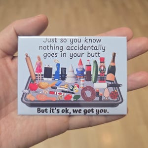 Puede incluir: Un im&aacute;n rectangular con el texto "Just so you know nothing accidentally goes in your butt. But it's ok, we got you." El im&aacute;n presenta una bandeja de objetos en miniatura, incluyendo una mu&ntilde;eca, una botella y un pepino.