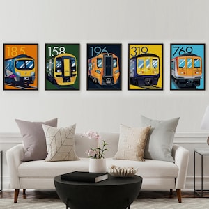 Op de afbeelding: Vijf ingelijste prints van verschillende treinmodellen, elk met een nummer aan de voorkant. De treinen zijn allemaal in verschillende kleuren, waaronder geel, blauw, oranje en groen. De lijsten zijn zwart en de achtergrond is wit.