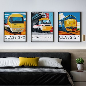 Op de afbeelding: Drie ingelijste prints van verschillende Britse treinmodellen. De eerste print toont een gele en rode trein met de tekst "InterCity 125 HST". De tweede print toont een gele en blauwe trein met de tekst "Class 370". De derde print toont een blauwe en gele trein met de tekst "Class 37".