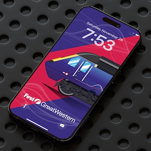Puede incluir: Un smartphone muestra una ilustración digital de un tren azul con detalles amarillos sobre un fondo rojo y azul. La pantalla muestra la hora 7:53 el sábado 26 de noviembre. El logotipo de First Great Western es visible.