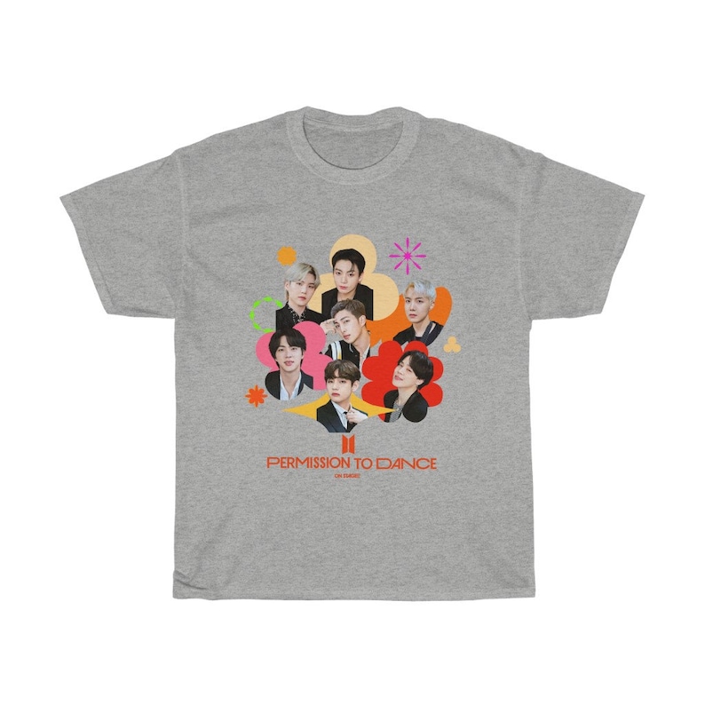 Peut inclure: Un t-shirt gris avec un motif color&eacute; du groupe de K-pop BTS. Le motif repr&eacute;sente les membres du groupe dans un collage de formes color&eacute;es avec le texte "Permission to Dance" en bas.
