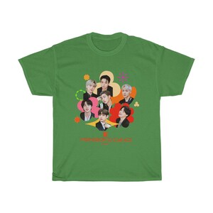 Peut inclure: T-shirt vert avec un graphique color&eacute; de sept hommes en cercle. Le graphique comprend le texte "Permission to Dance" en orange.