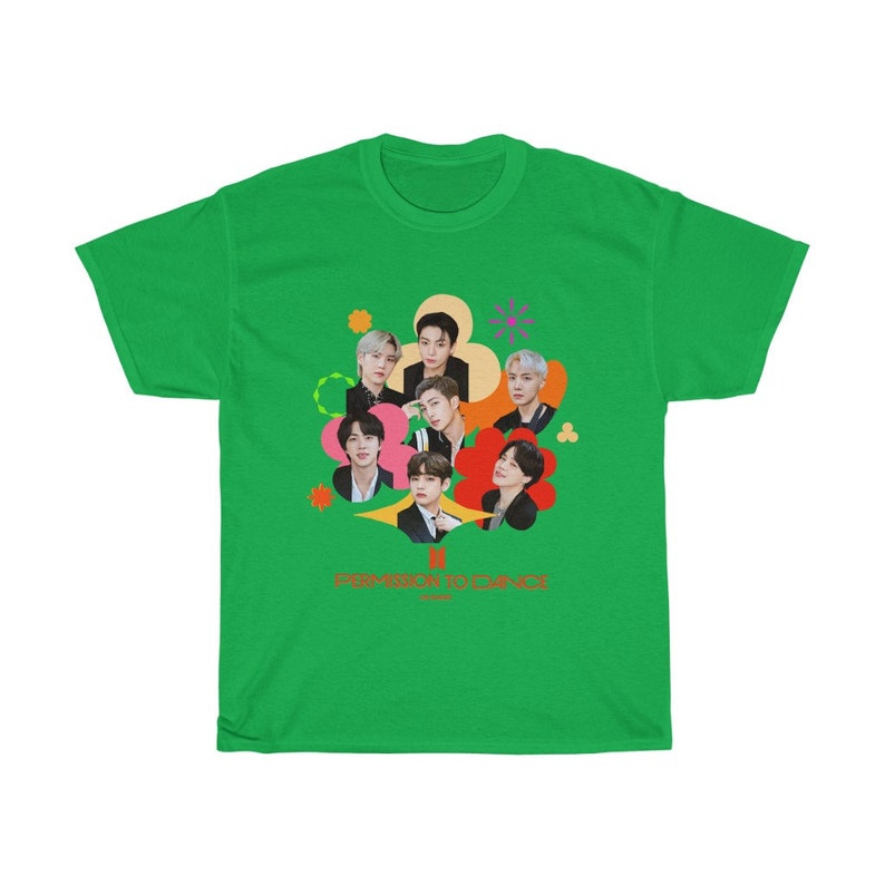 Peut inclure: T-shirt vert avec un motif color&eacute; de sept hommes en cercle. Le motif comprend le texte "PERMISSION TO DANCE" en orange.