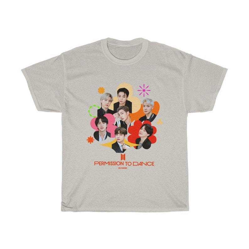 Peut inclure: Un t-shirt gris clair avec un motif color&eacute; du groupe de K-pop BTS. Le motif repr&eacute;sente les membres du groupe dans un collage de cercles et de fleurs color&eacute;s. Le texte "Permission to Dance" est imprim&eacute; sous le motif.