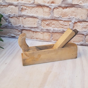 raboteuse à bois vintage, rabot de menuiserie, outil à bois à main, vieux ciseau, raboteuse primitive, outil rétro, décor rustique.