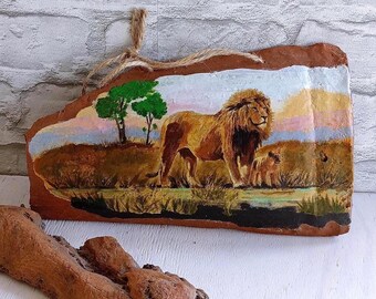 Artistic decoupage on clay tiles. Old decorated brick. Lioness with cub. Wall ceramic tiles. Decor with a lion. Ceramics on the wall.