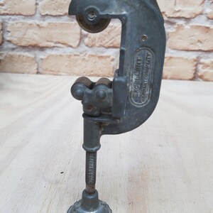 May include: A silver pipe cutter with a black handle and a screw adjustment. The cutter is labeled "EXCELLENT QUALITY".