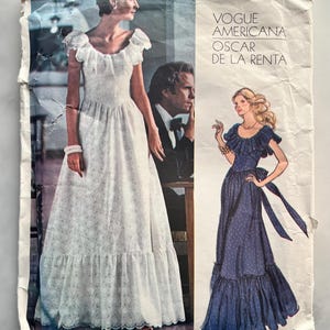 Könnte beinhalten: Vintage Vogue Americana Oscar de la Renta Schnittmuster. Das Muster zeigt Illustrationen von zwei eleganten Kleidern. Eines ist ein weißes Rüschenkleid, das andere ein marineblaues Kleid mit einer Schleife.