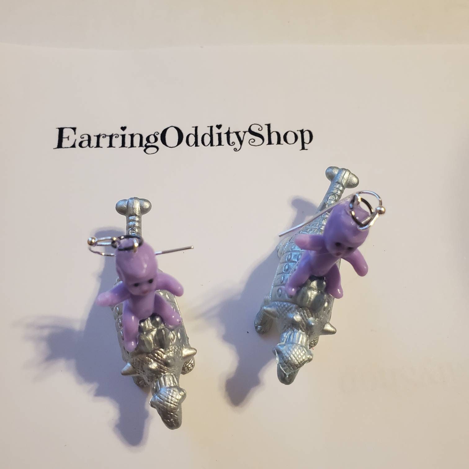 Babies riding dinosaur earrings