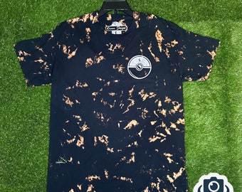 May include: Black tie-dye t-shirt with a white graphic of a Pokeball with a lightning bolt on it. The shirt has the text "Gamer Designs" on the tag and on the bottom of the shirt.