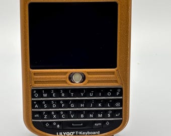 May include: A brown and black handheld device with a QWERTY keyboard and a small screen. The device is labeled "LILYGO T-Keyboard".