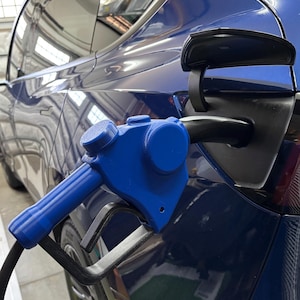 May include: A blue electric vehicle charging handle with a black cable attached to a blue electric car.