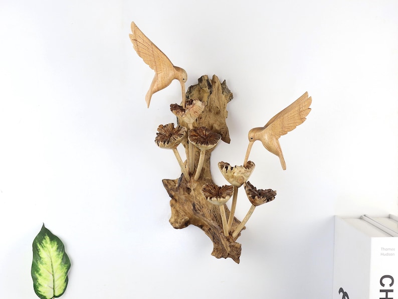 Hand carved wooden hummingbird wall art, multiple hummingbird heads emerging from a natural wood branch.